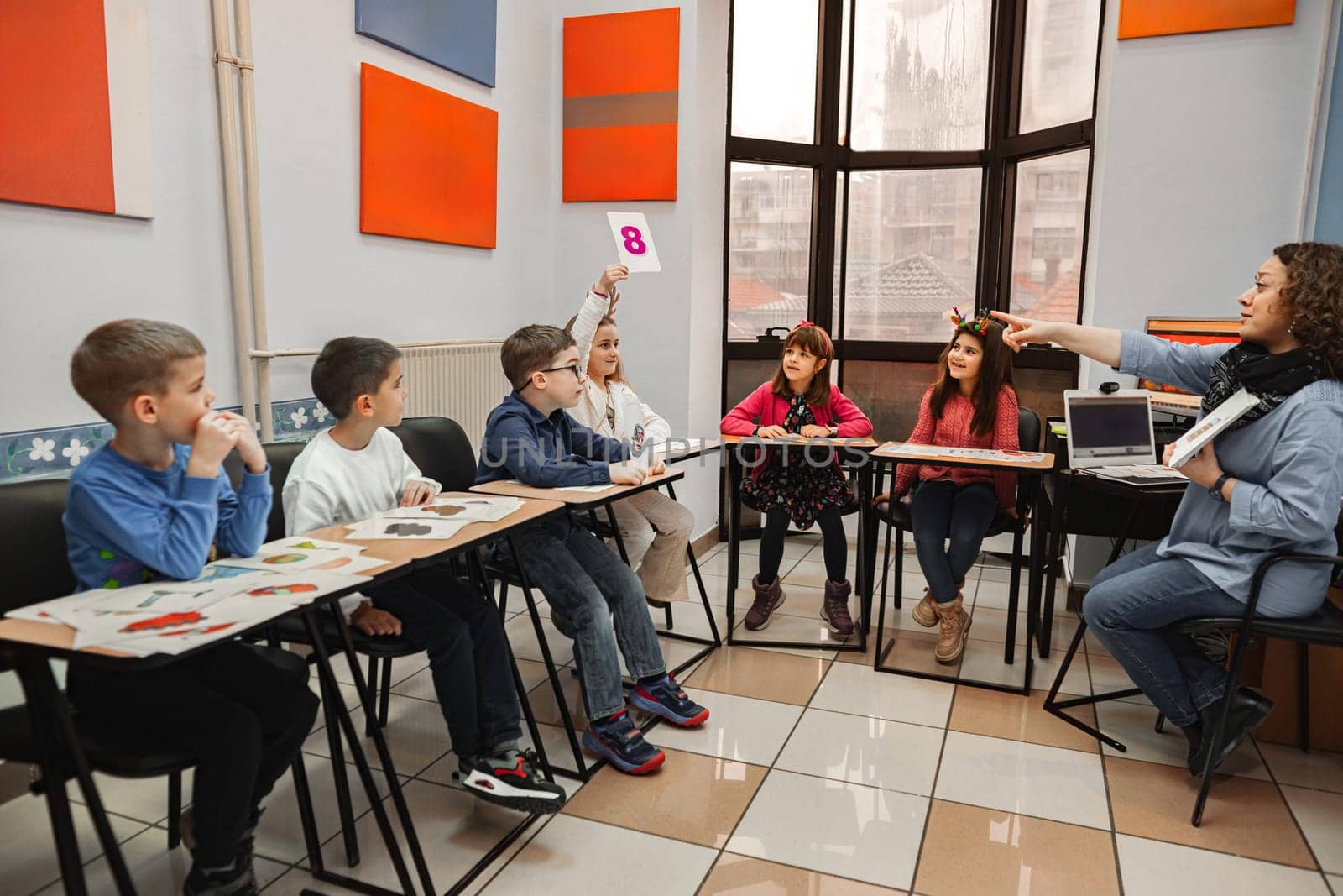 Woman teaching a group of elementary students at language school.