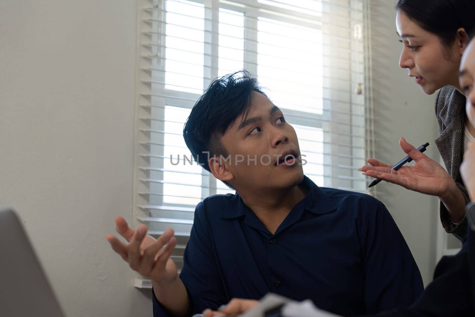 A team engages in a discussion about project issues, showing visible frustration and the need for effective communication.