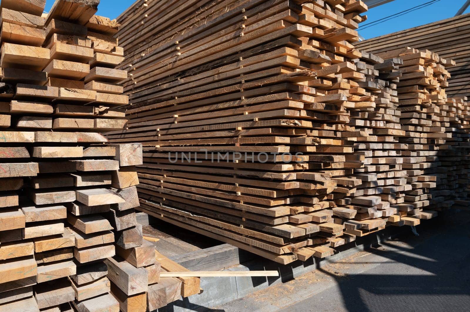 Stacked wooden planks close-up at lumber warehouse. Wood industry concept