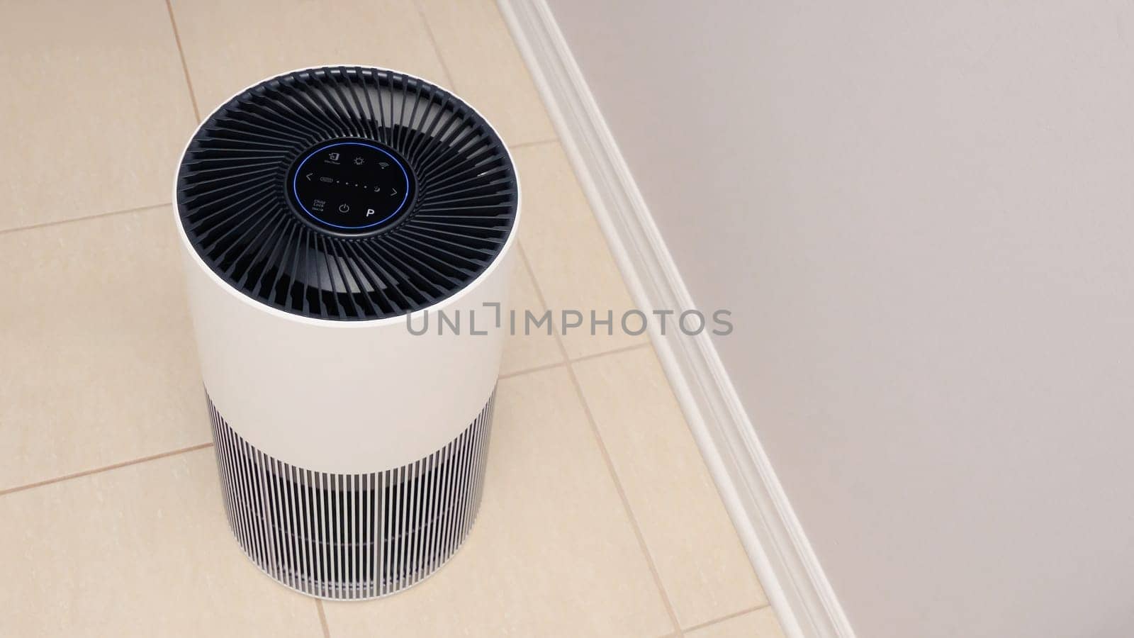 Sleek Modern Tall Air Purifier with Black Fan on Beige Tile Floor in Stylish Room.