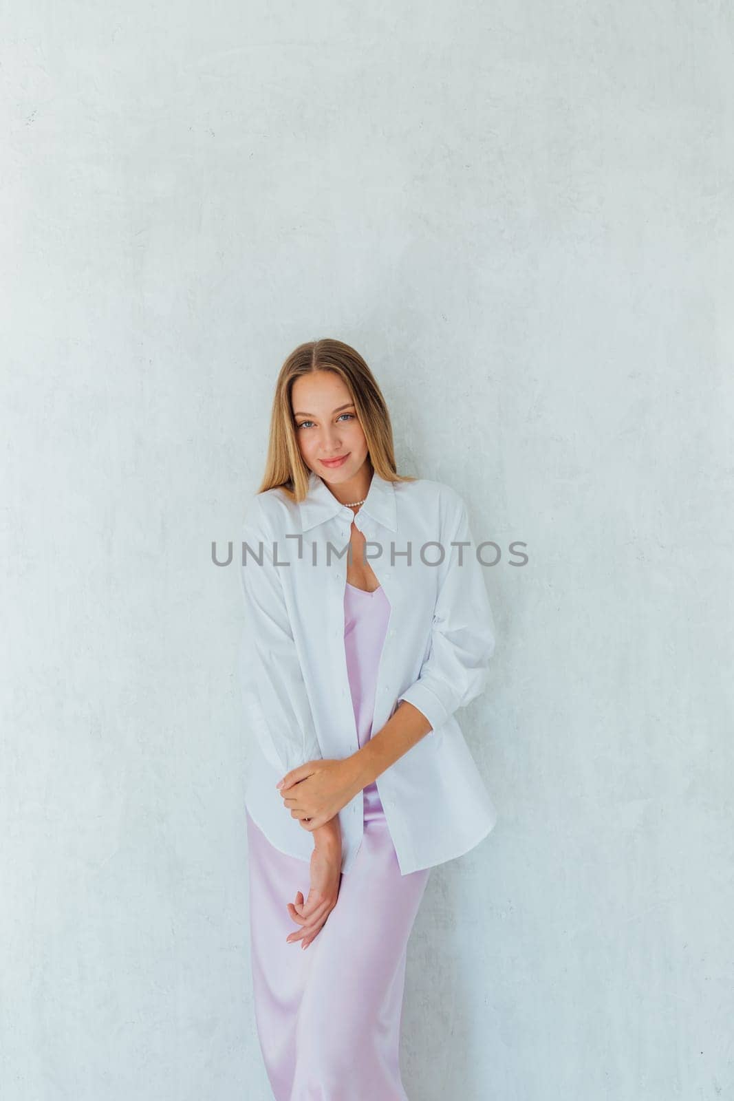 Portrait of a beautiful fashionable slender blonde woman in light summer clothes