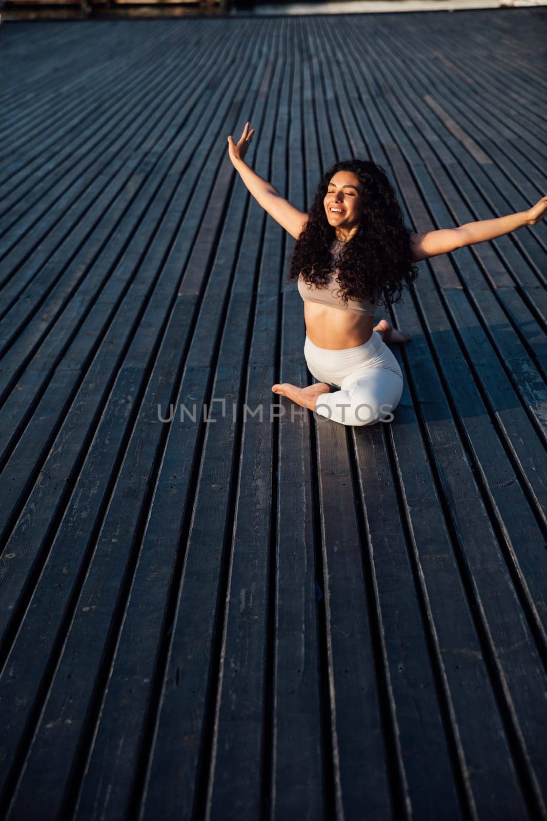 Brunette woman doing gymnastics yoga asana outdoors