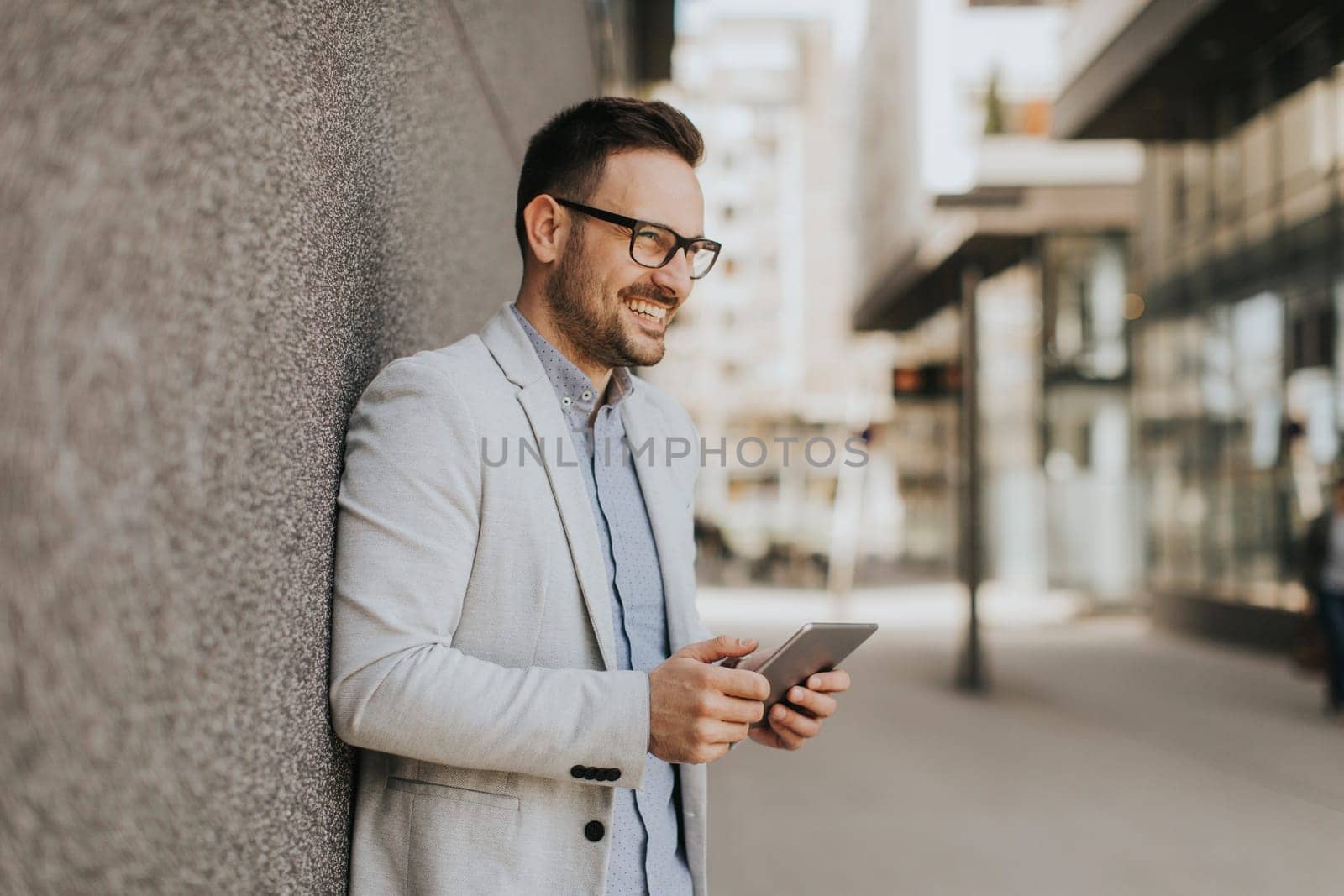 Portrait of a young businessman holding digital tablet outdoor in urban enviroment