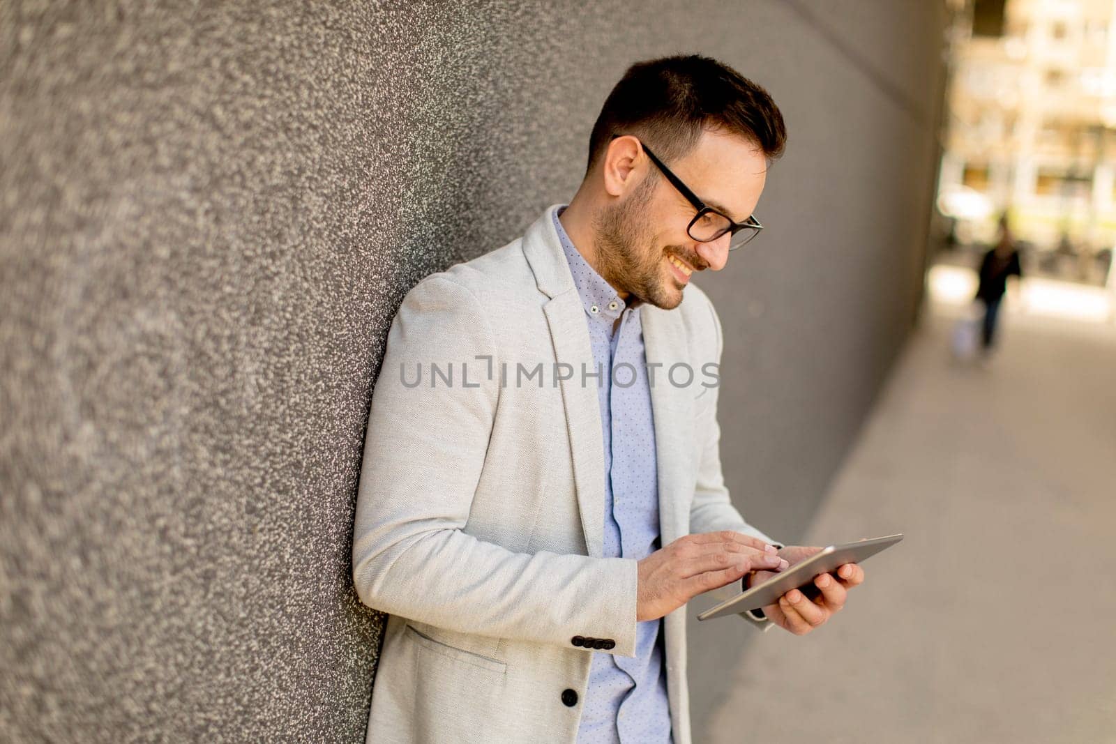 Portrait of a young businessman holding digital tablet outdoor in urban enviroment