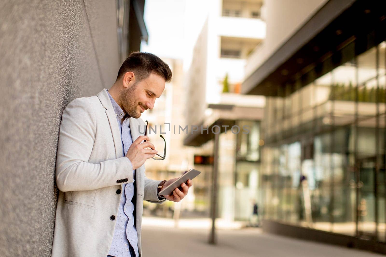 Portrait of a young businessman holding digital tablet outdoor in urban enviroment
