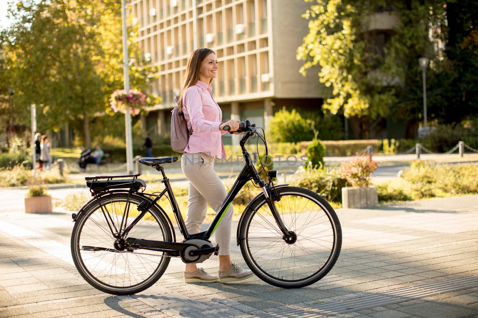 Pretty young woman with modern city electric e-bike clean sustainable urban transportation