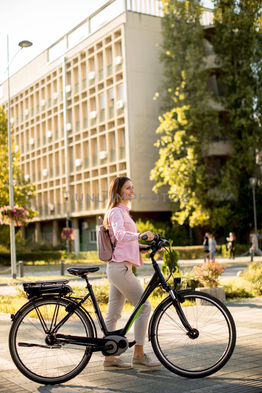 Pretty young woman with modern city electric e-bike clean sustainable urban transportation