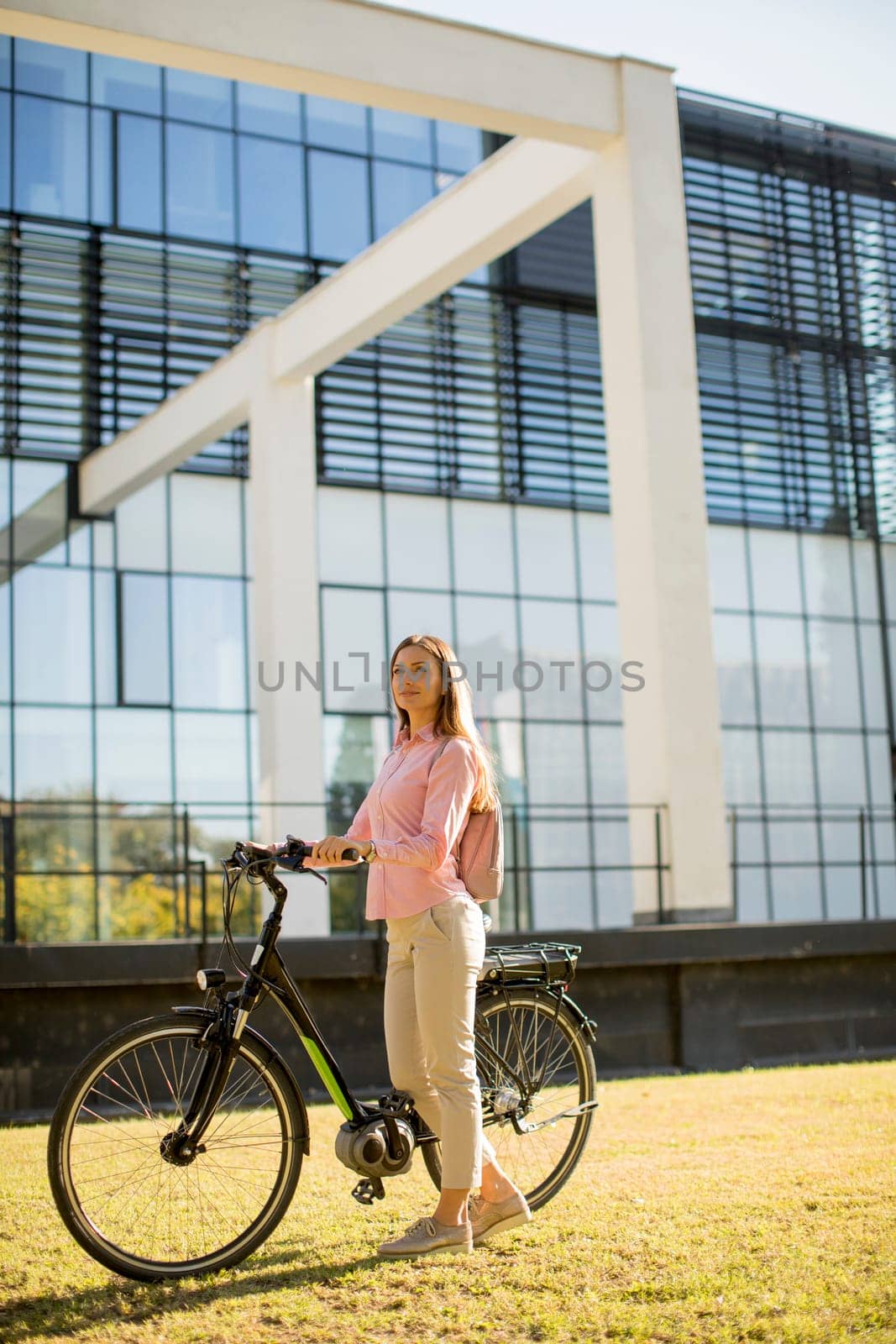 Pretty young woman with modern city electric e-bike clean sustainable urban transportation