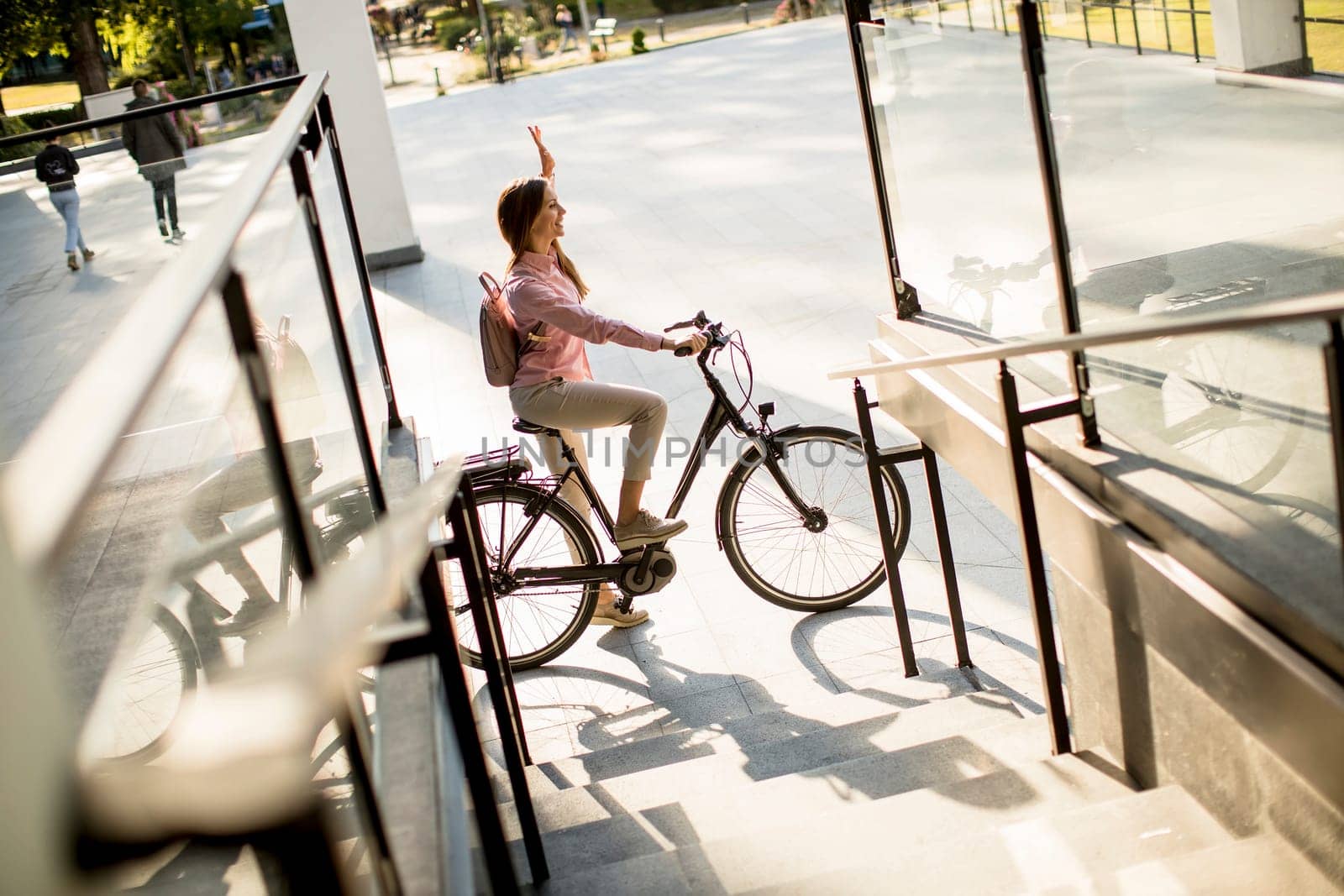 Young woman riding e bike in urban enviroment at sunny day