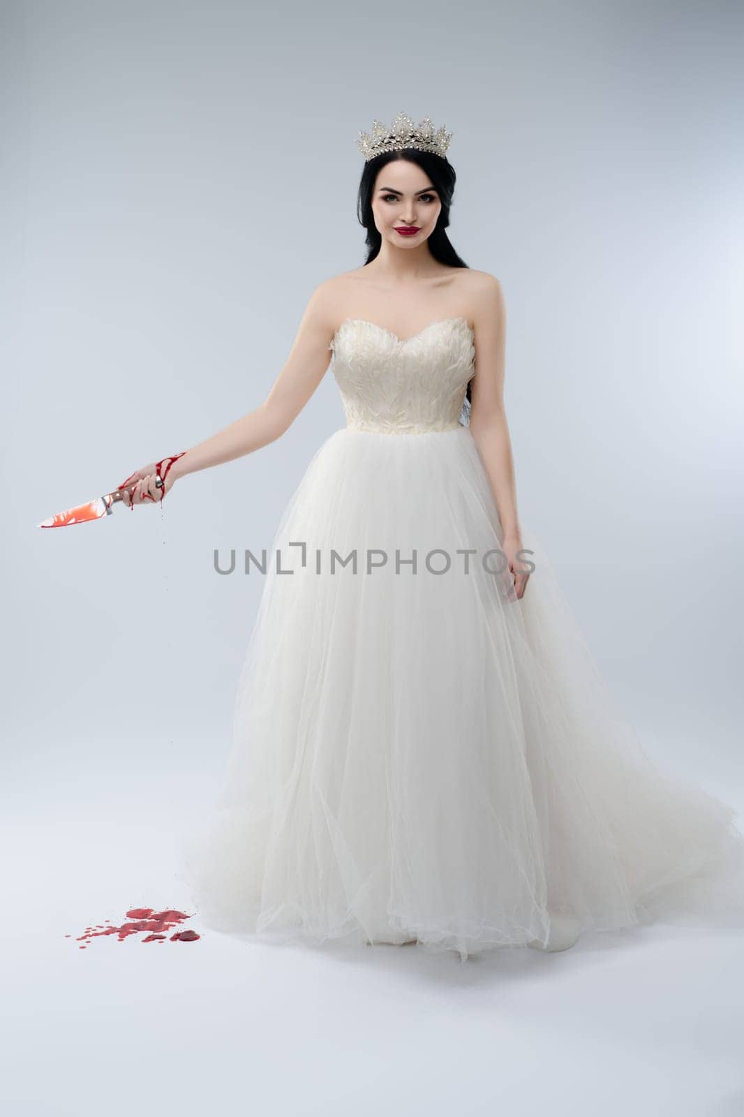 A striking woman in a beautiful white wedding gown holds a bloody knife, embodying a darkly enchanting bridal fantasy.