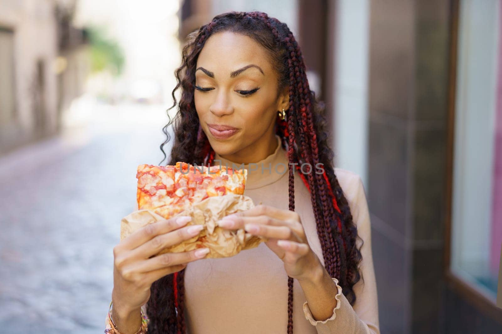 A joyfilled woman savoring a delicious slice of pizza in a charming and picturesque alley, radiating pure happiness and appreciation for the simple yet delightful experience of good food