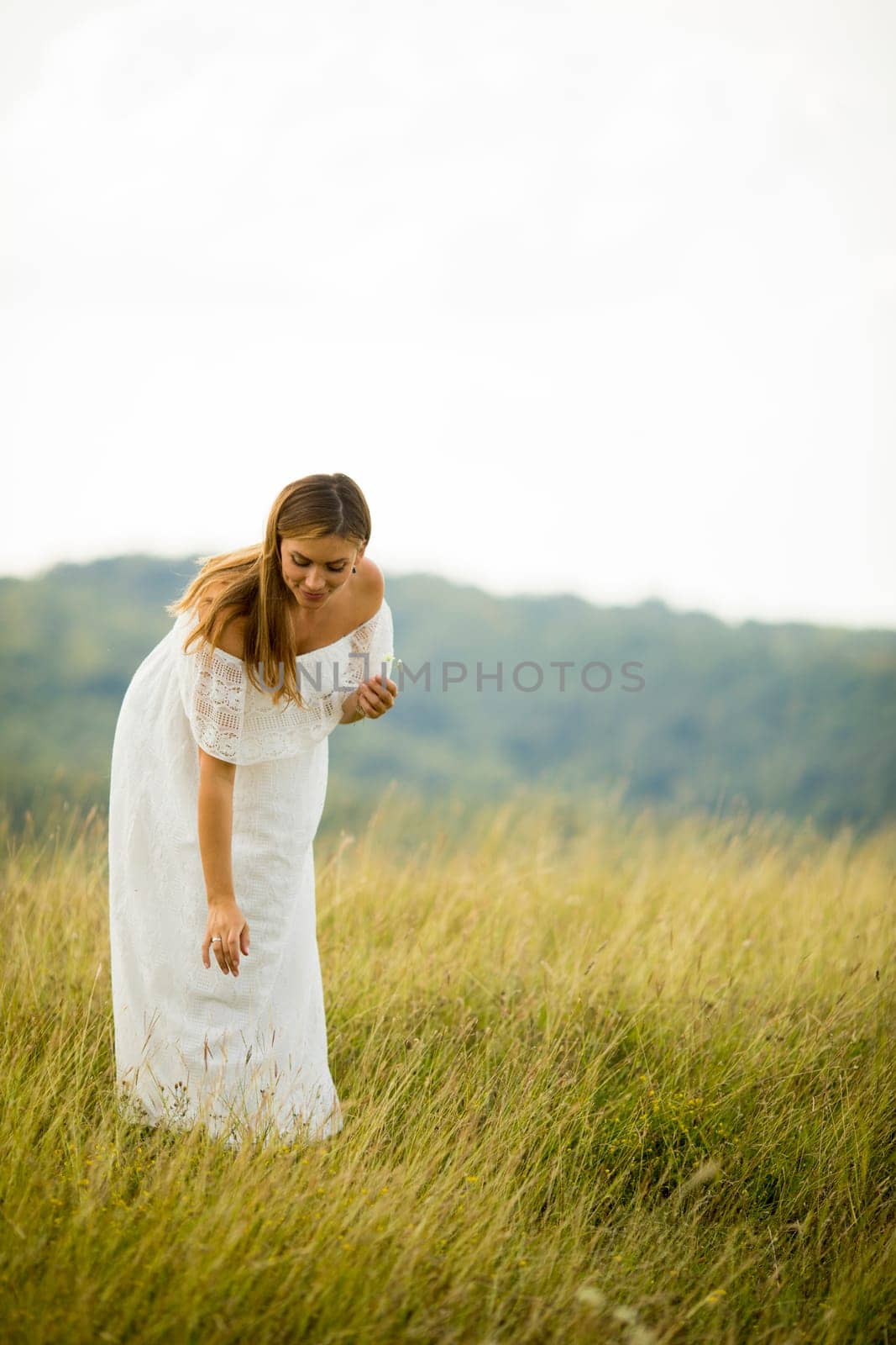 Young pregnant woman relaxing outside in nature at summer day