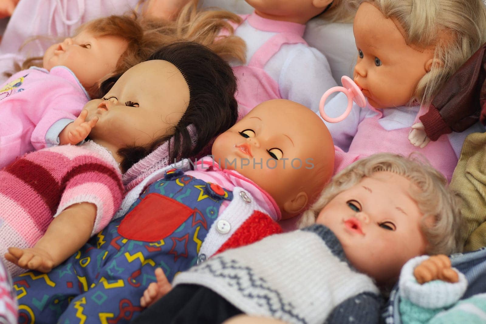 Many vintage dolls in a hat at the flea market