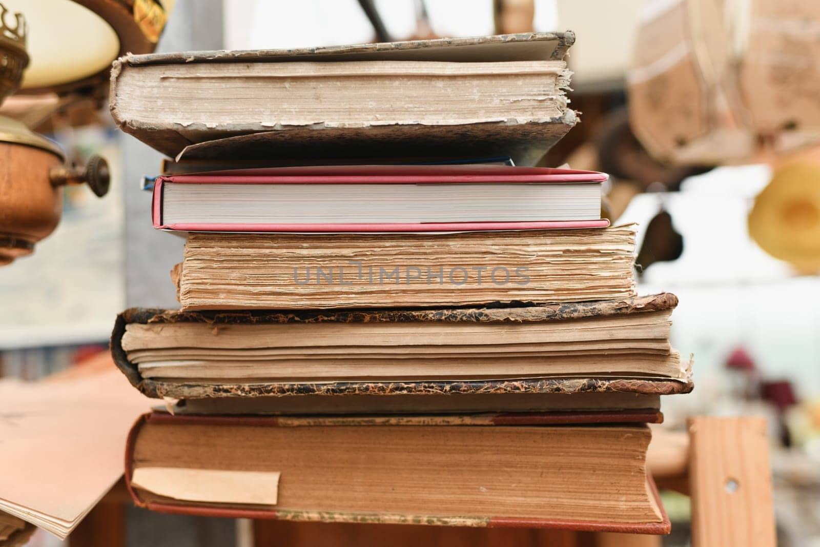 Stack of worn tattered antique books in a vintage store
