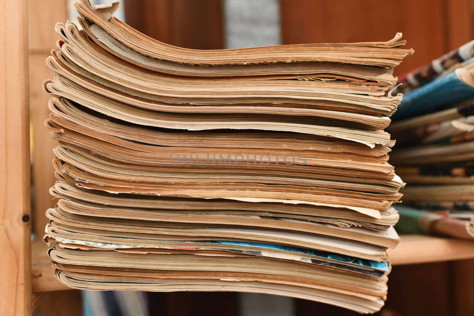 Stack of worn tattered antique newspapers or magazines in a vintage store