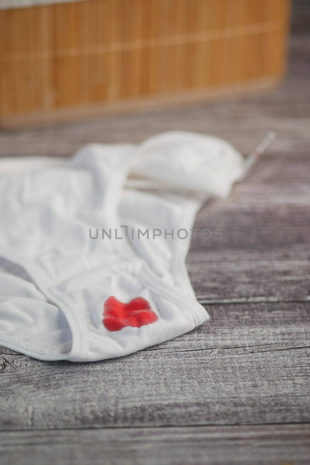 White underwear with period stain on wooden table.