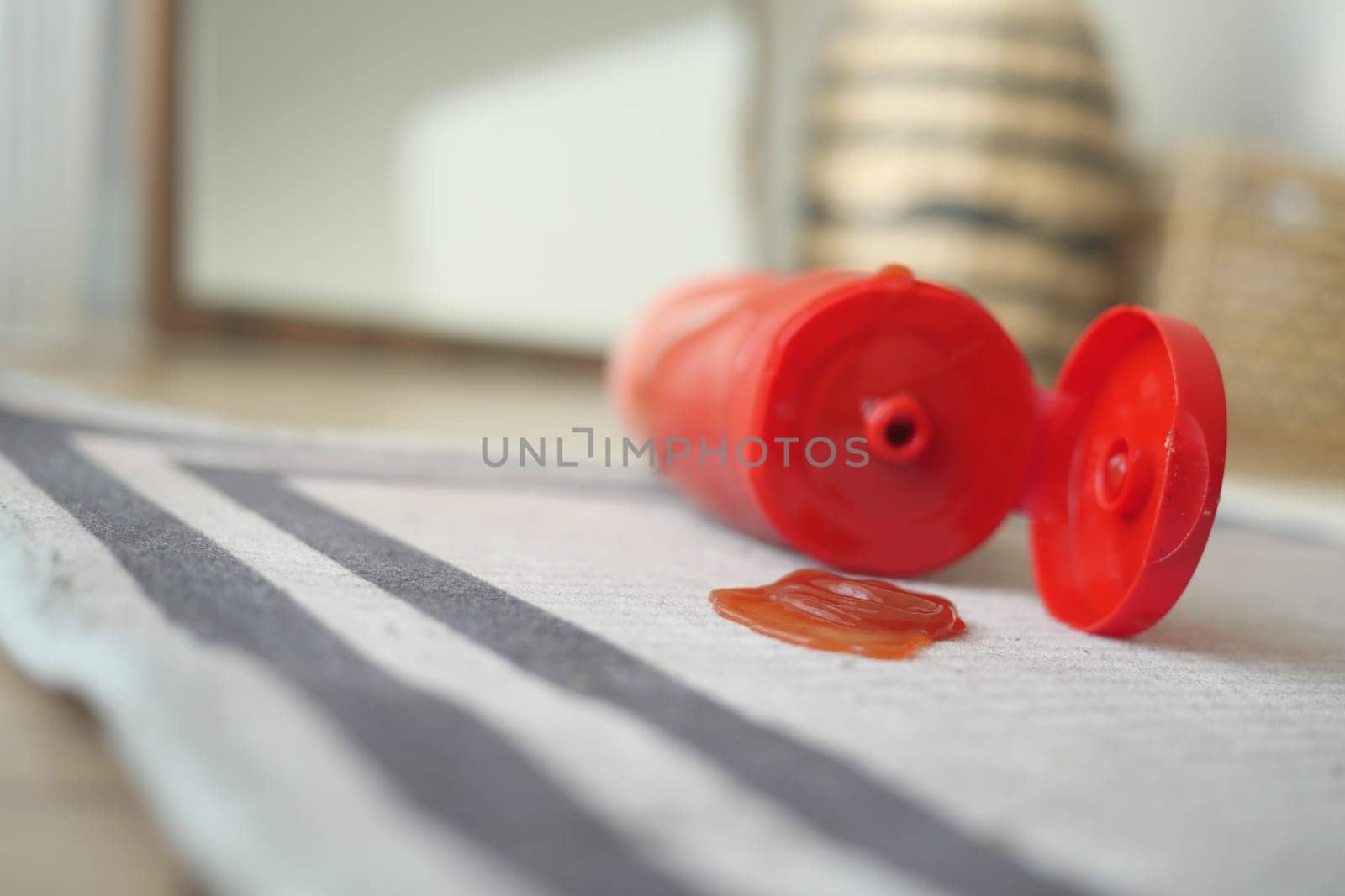Bright room features a ketchup bottle tipped over, spilling sauce.