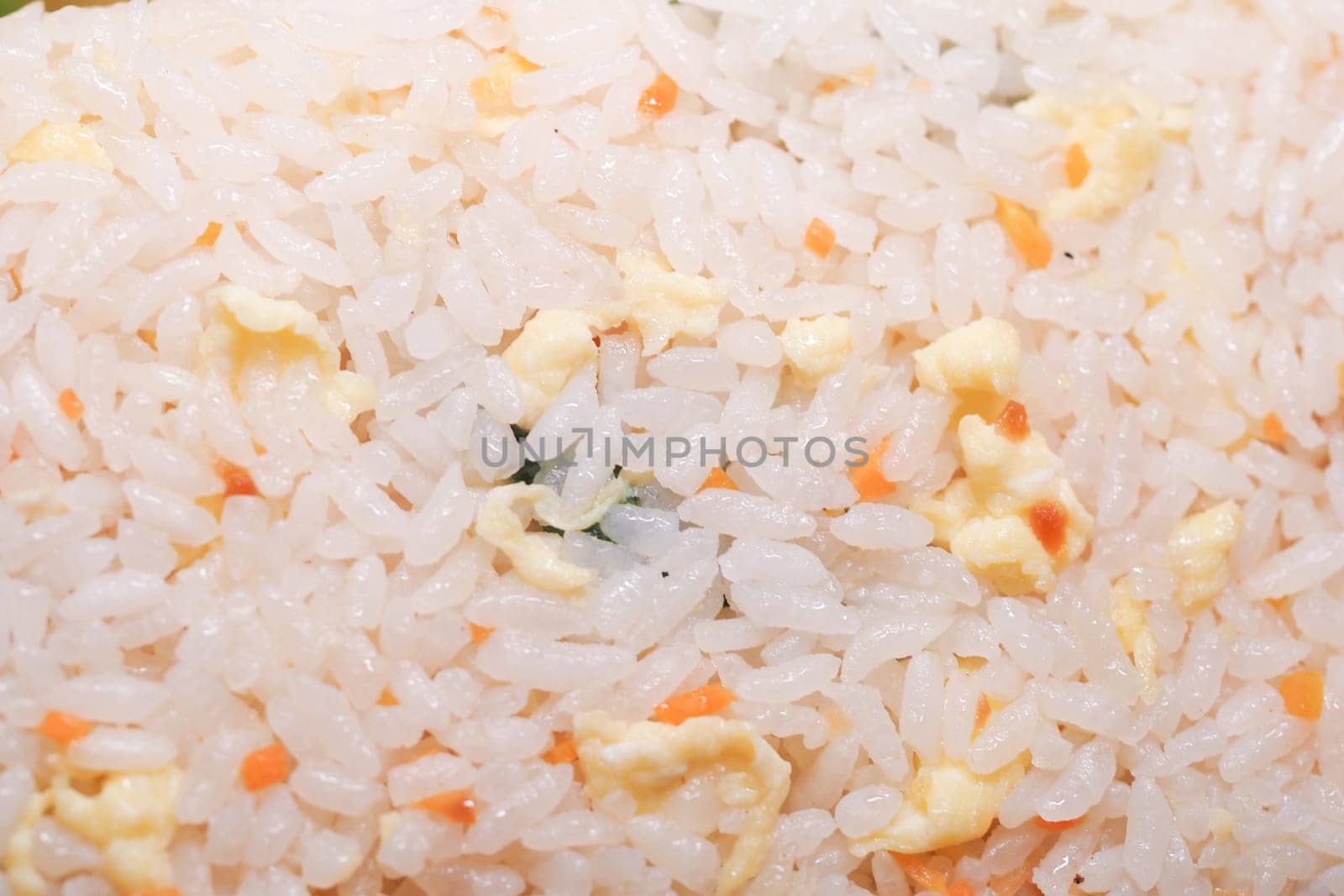 A colorful dish of fried rice featuring vegetables and egg pieces.