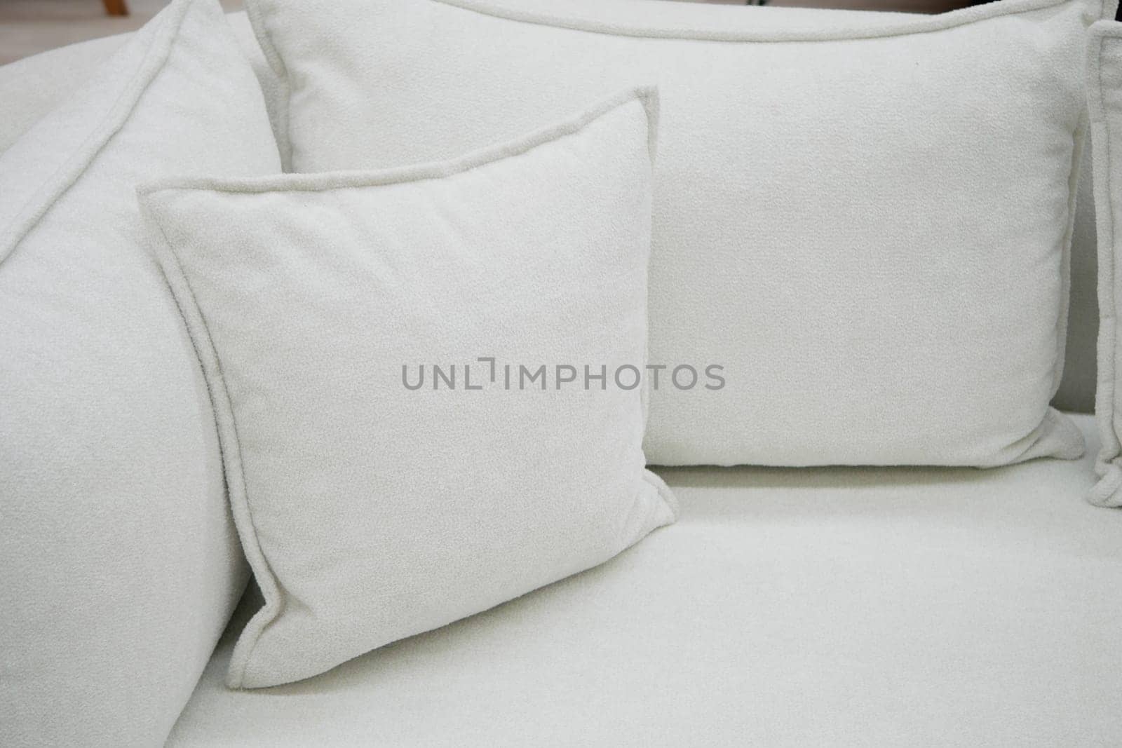 Soft white sofa with fluffy pillows invites comfort and relaxation.