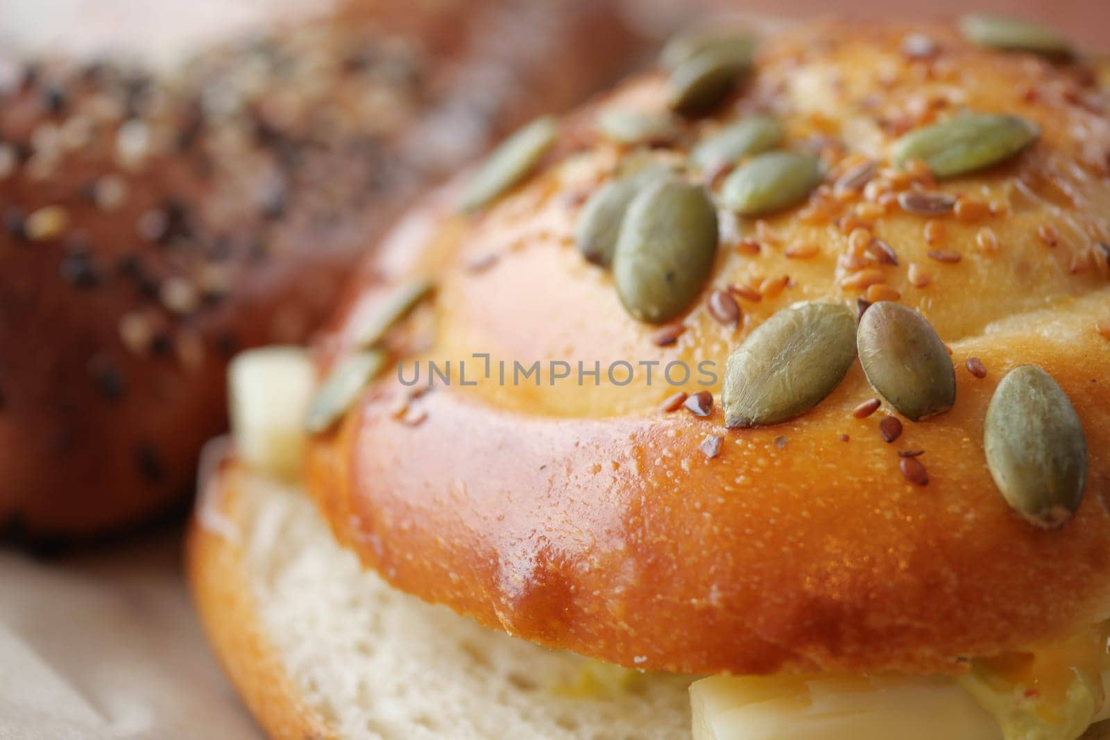 Delicious baked bread rolls topped with seeds in a warm bakery.