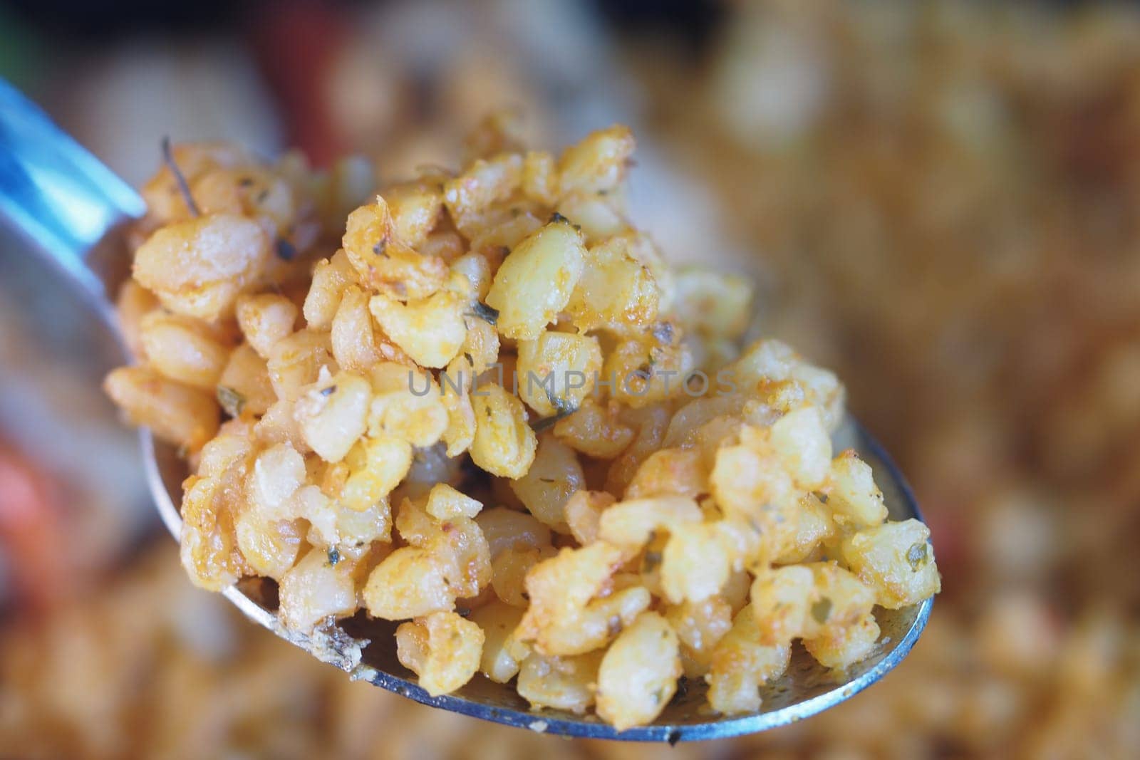 Golden rice grain captured on a shiny spoon, perfect for culinary themes.