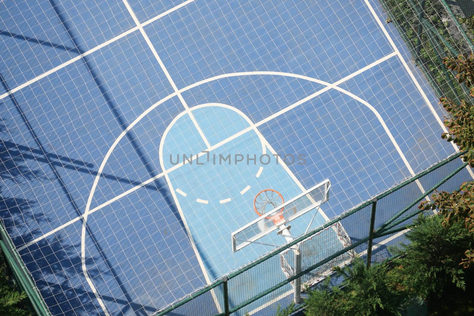 Overhead view of a vibrant basketball court on a sunny day.