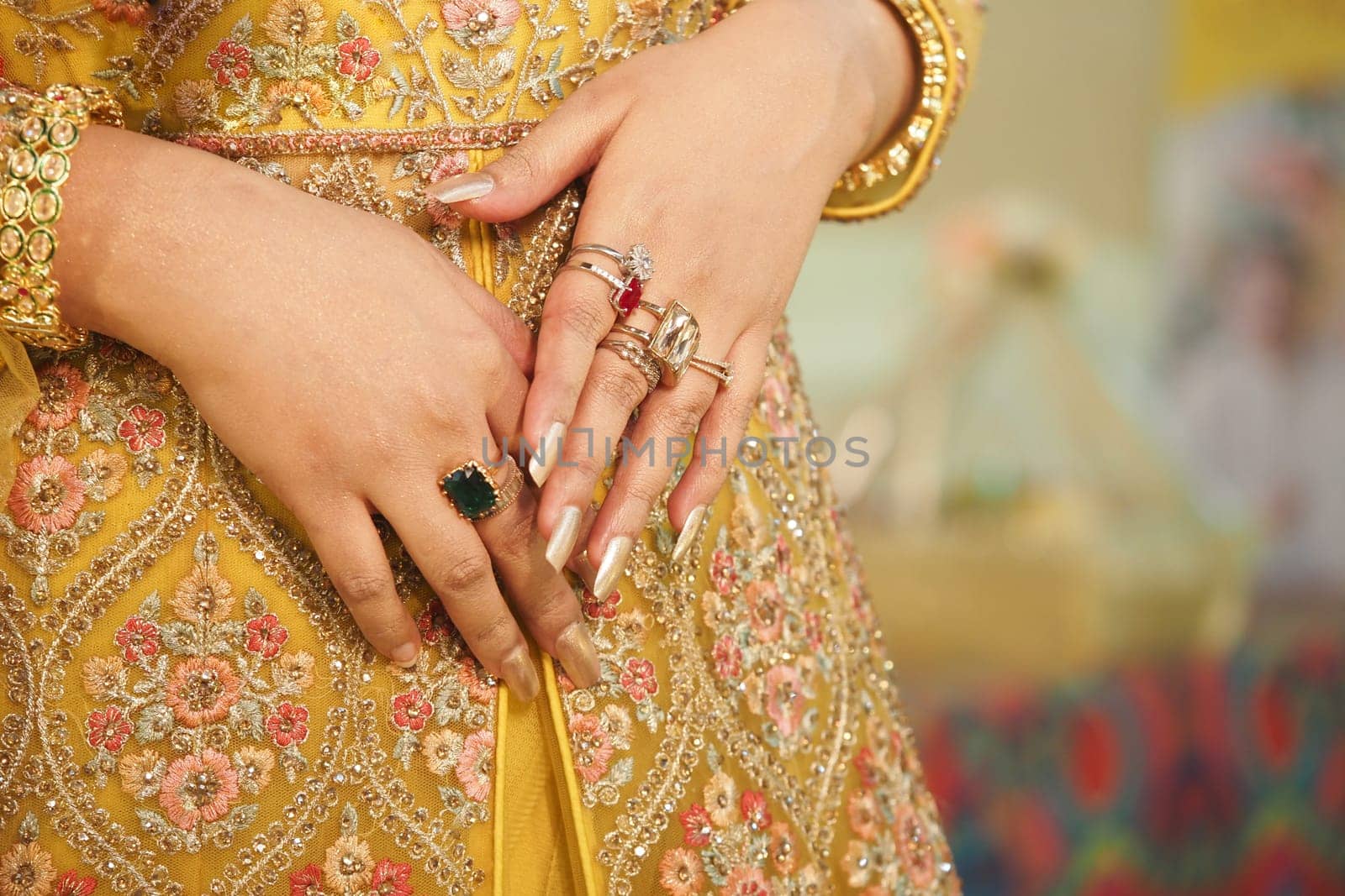 Beautifully decorated hands showcase stunning rings and vibrant attire.