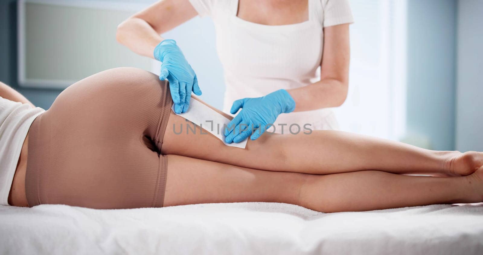 Professional Beautician Performing Leg Waxing on Client at Beauty Clinic