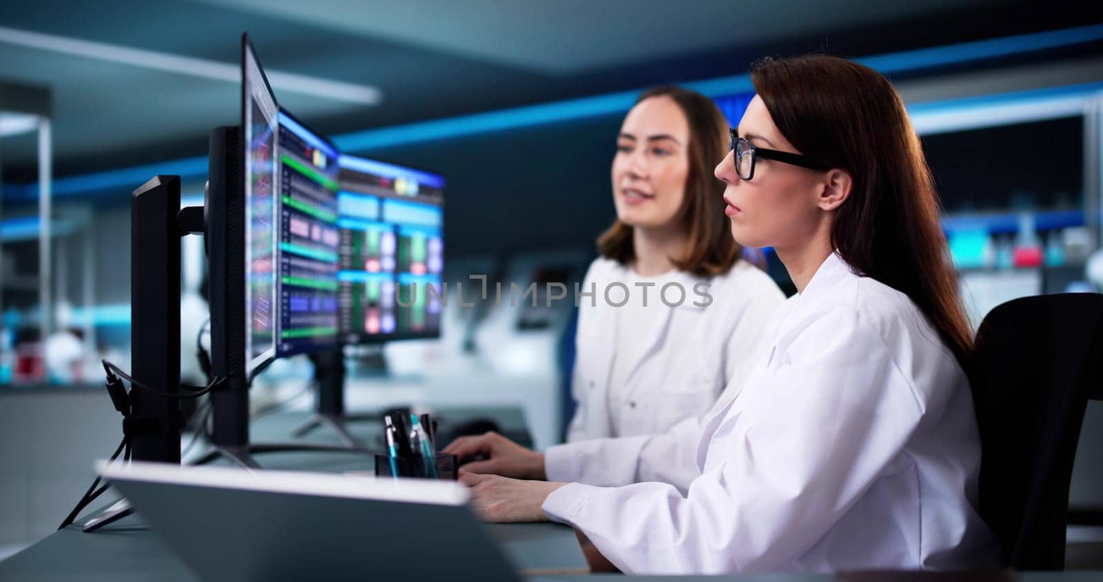 Female research scientist analyzing data on multiple computer screens
