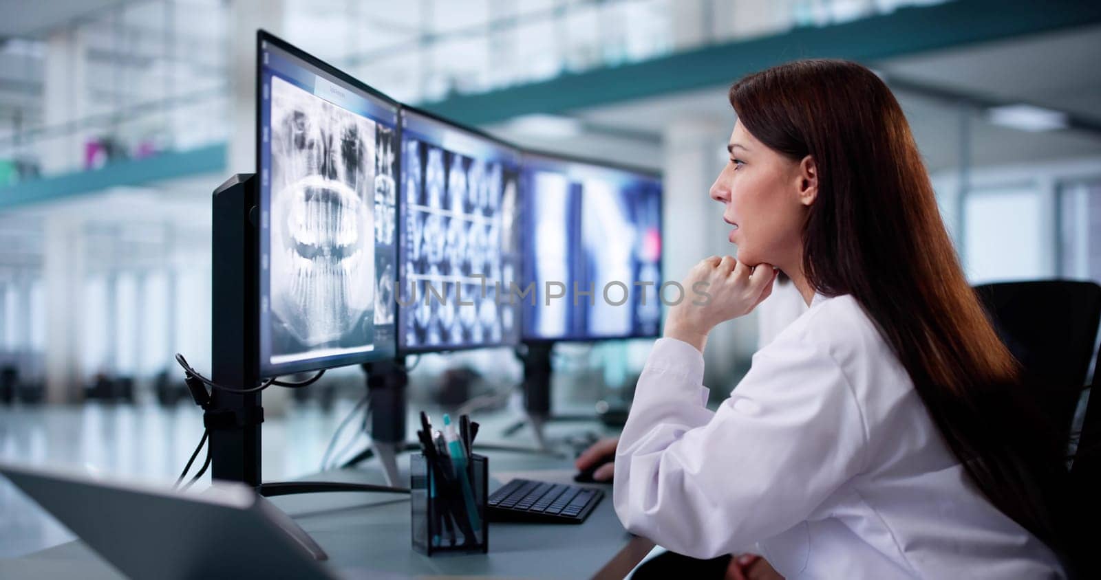 Female Dentist Examining X-Ray of Patient's Teeth Using Software