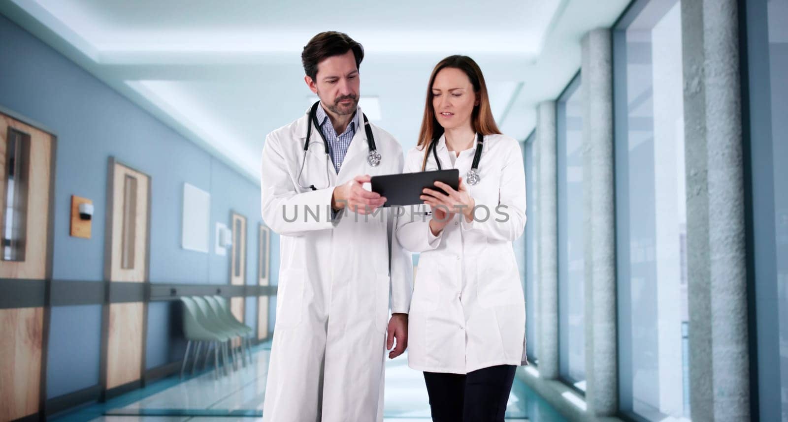 Doctors consult in hospital, discussing patient cases and treatment options.