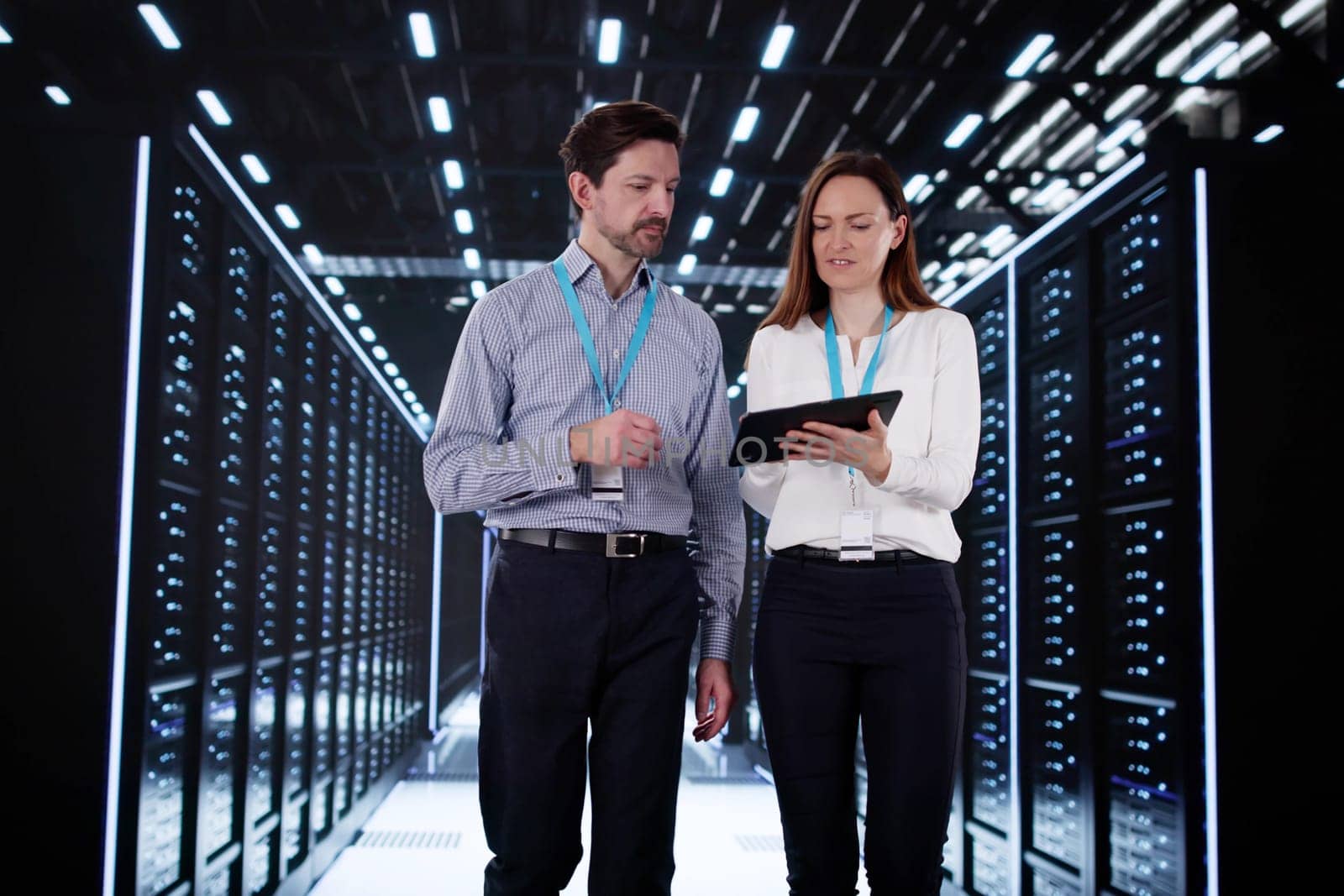 Engineers configuring AI technology in data center server room.
