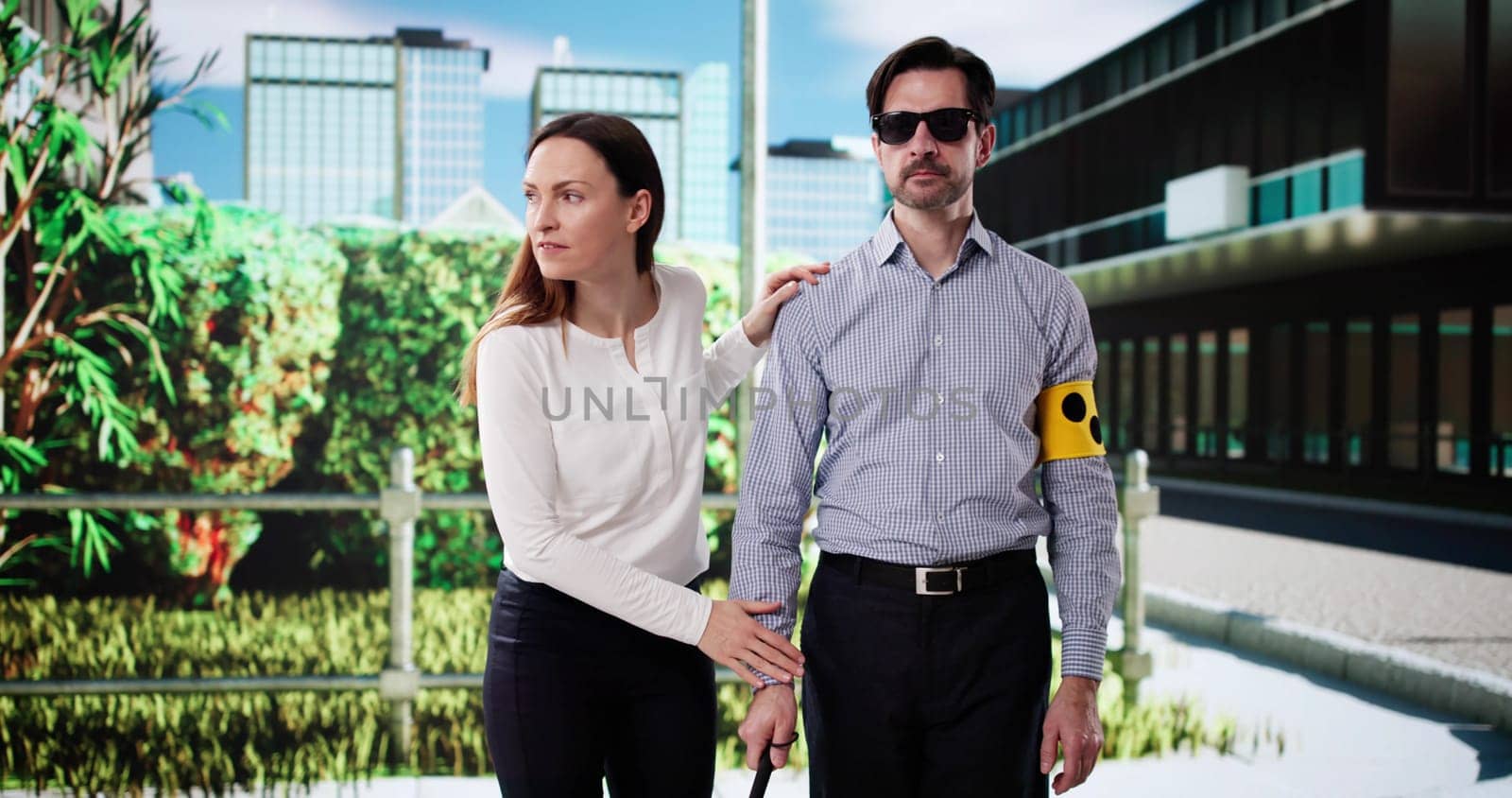 Compassionate woman guides visually impaired man across busy city street.