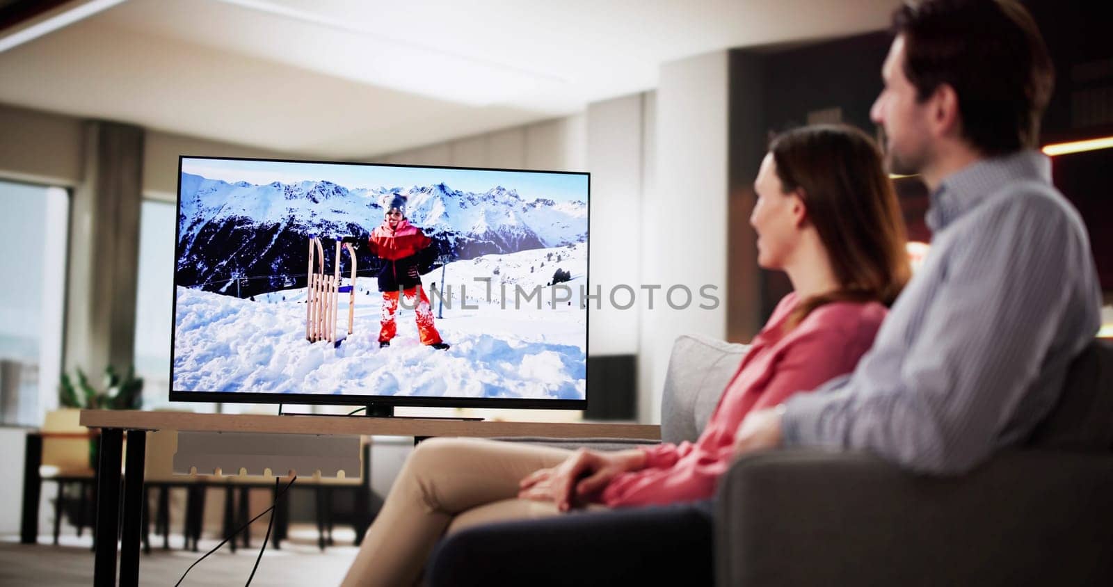 Relaxed couple enjoying movie night in cozy living room at home.