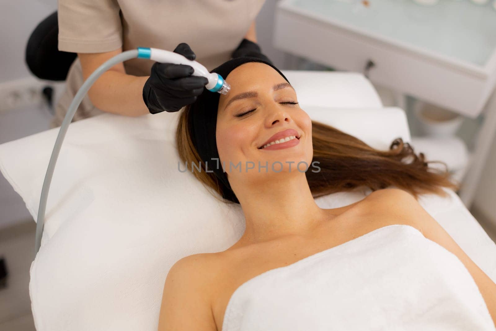 A skilled therapist performs a skin treatment that rejuvenates and hydrates while removing impurities, leaving the client refreshed and relaxed in a tranquil spa atmosphere.