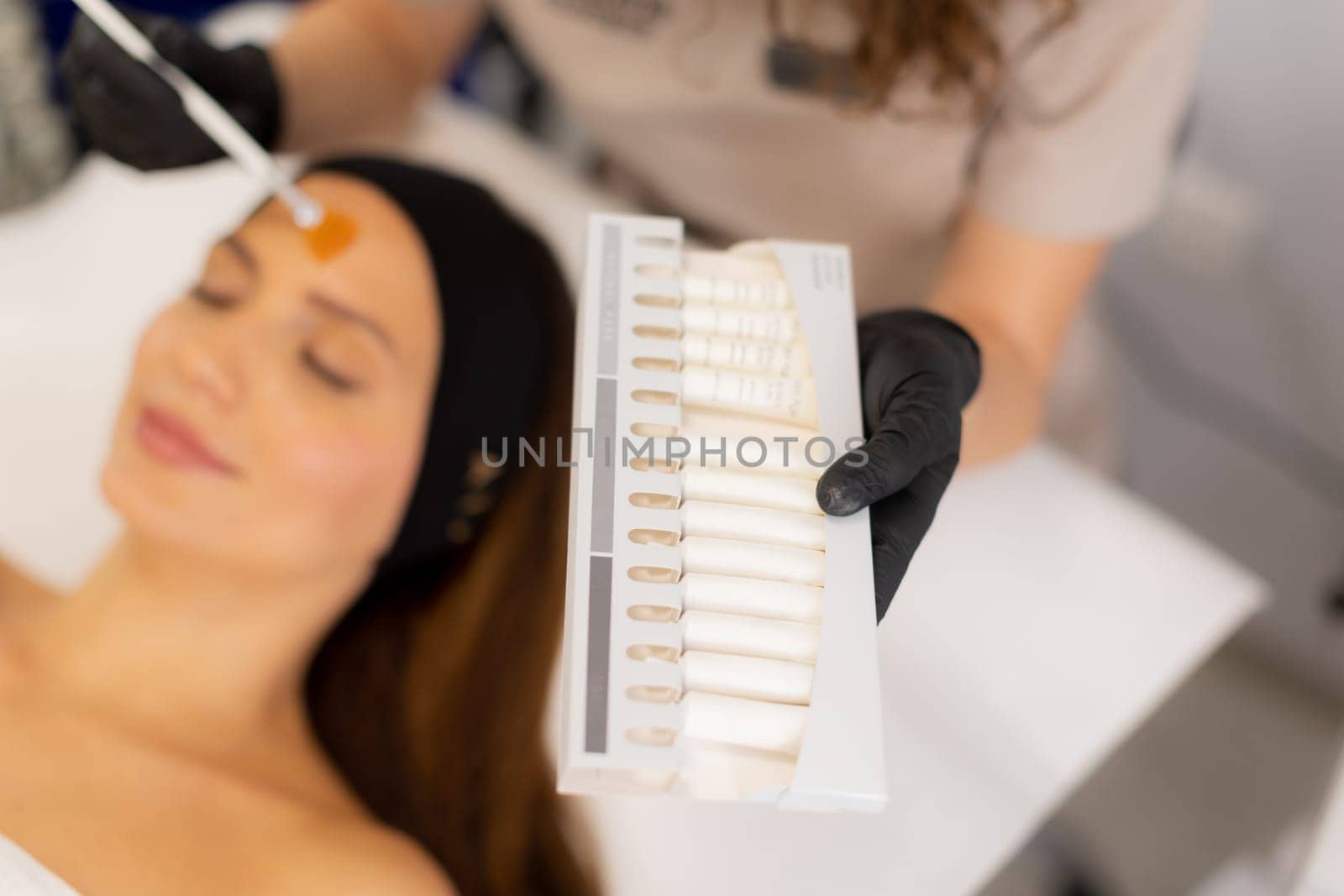 A beauty therapist applies a rejuvenating cream to a client's face, aiming to enhance moisture and reduce wrinkles. The treatment unfolds in a tranquil salon environment.