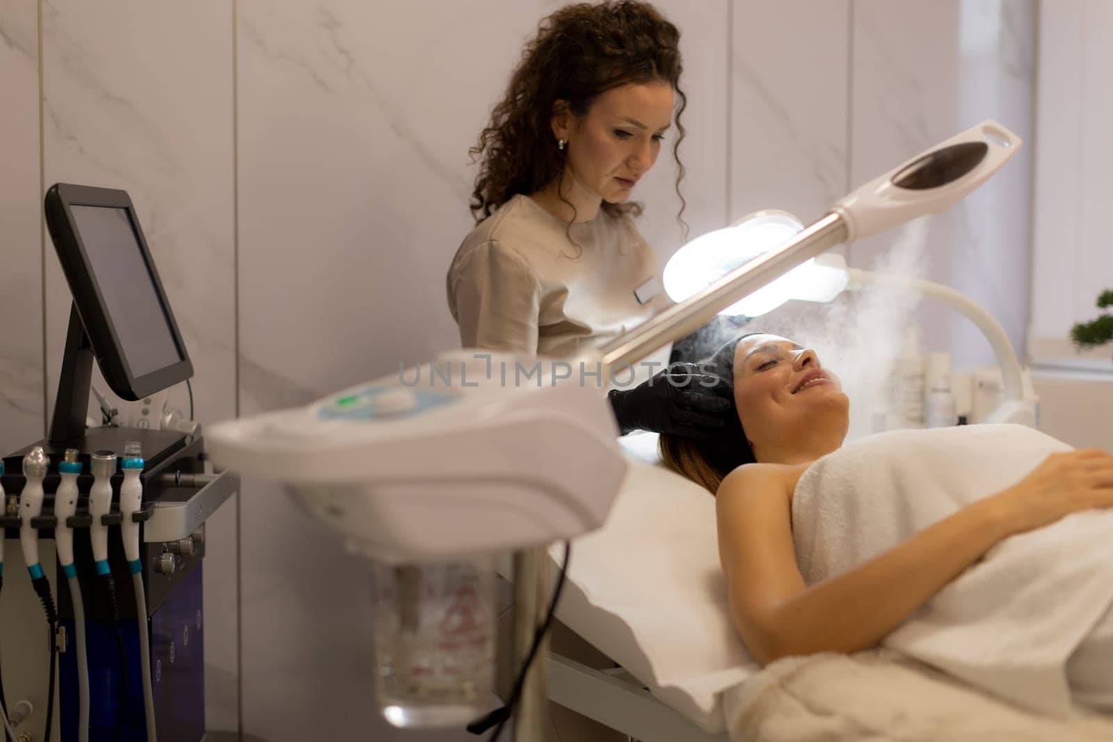 A tranquil spa setting features a woman enjoying a facial treatment, with mist enveloping her face. The atmosphere promotes relaxation and skincare rejuvenation.