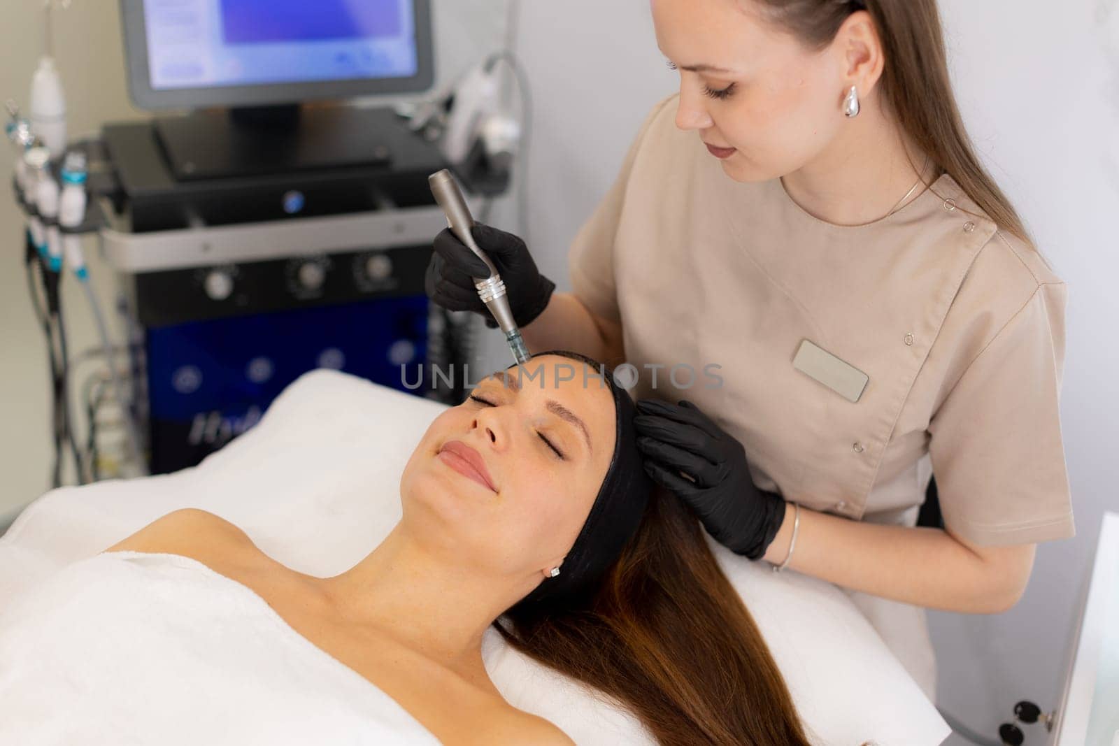 A skilled professional uses a microneedling mesotherapy device on a client in a serene clinic, focusing on skin rejuvenation and enhancing beauty. The environment is calm and sterile.