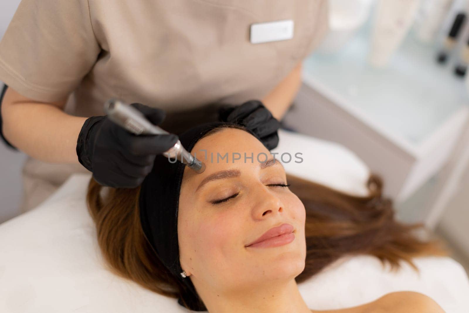 A skilled practitioner performs microneedling on a relaxed client, enhancing skin texture and rejuvenation. The tranquil spa ambiance promotes a sense of calm and well-being.