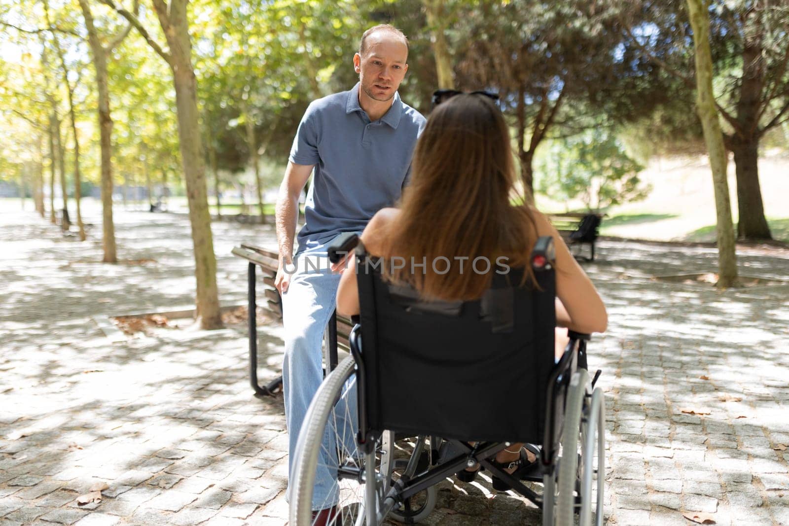 Man and woman having conversation in park, demonstrating care and support for people with disabilities