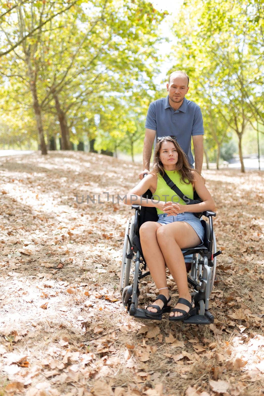 Nurse assisting disabled woman enjoying a sunny day in park