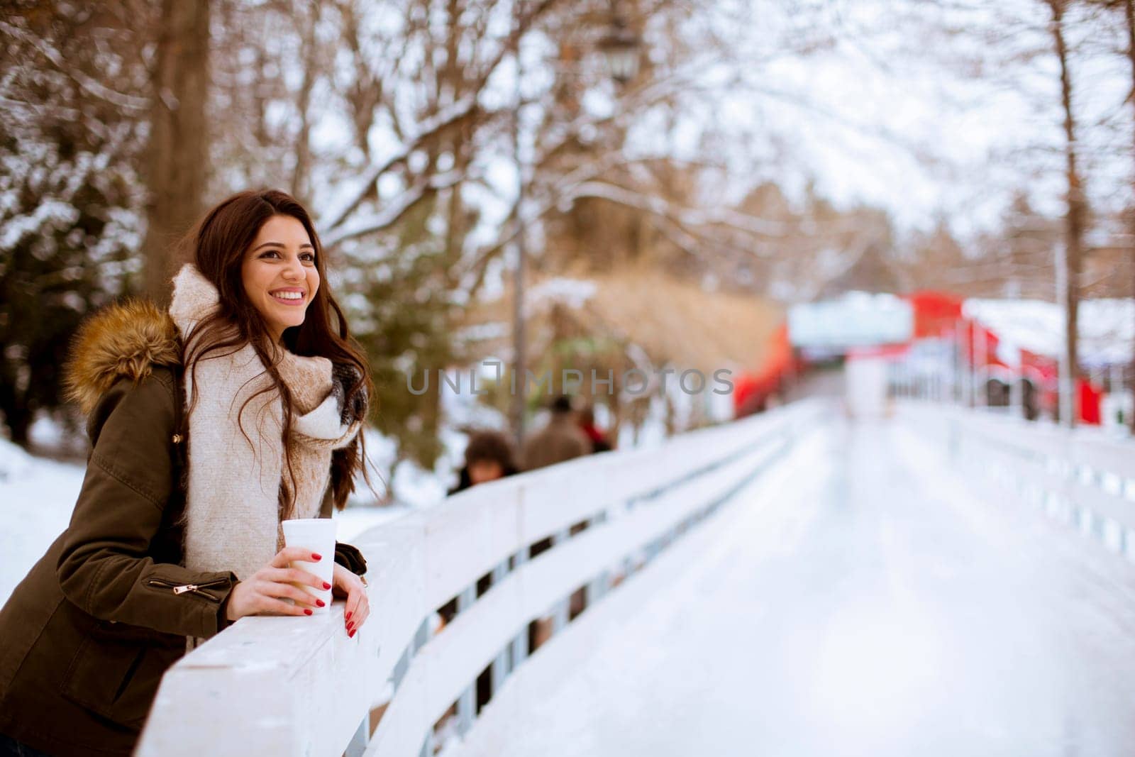 Young woman drinking tea or coffee over winter nature background outdoor