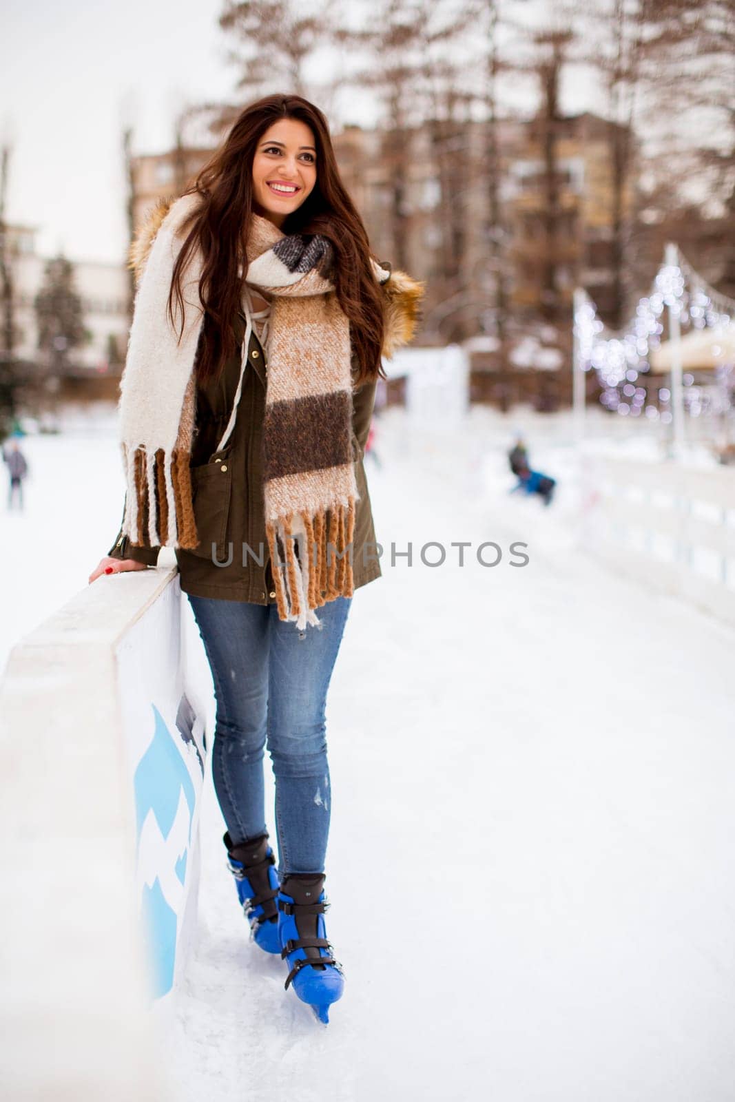 Portrait of young woman rides ice skates in the park