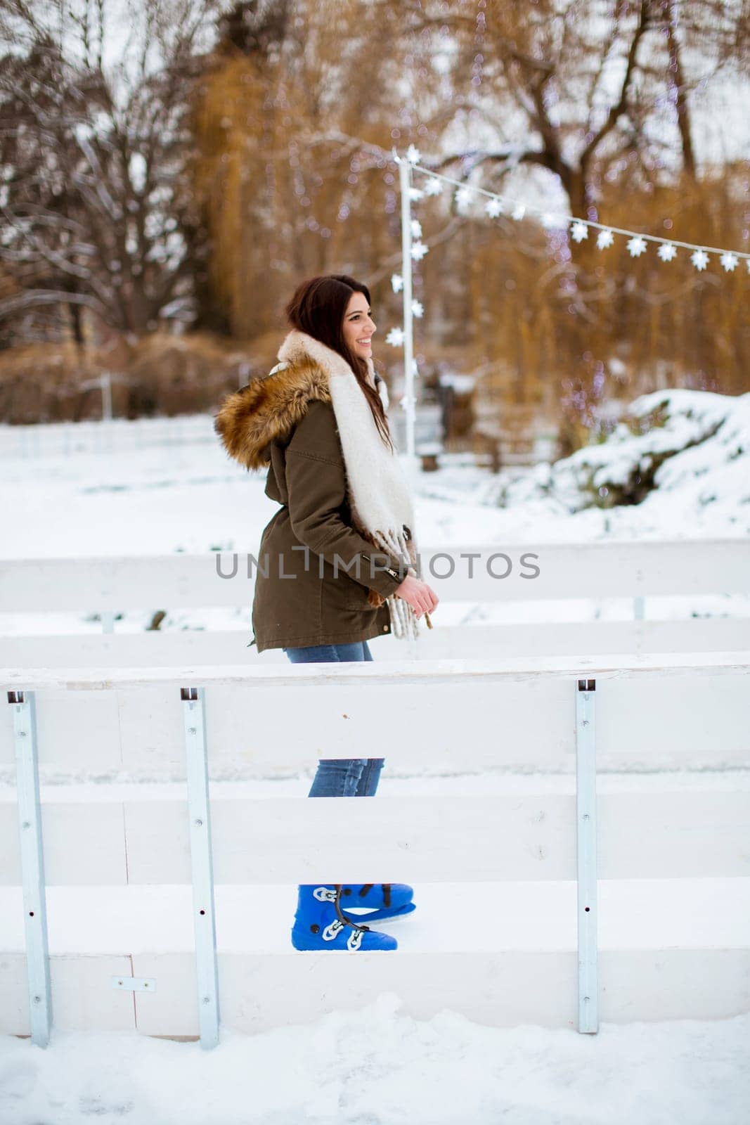 Portrait of young woman rides ice skates in the park