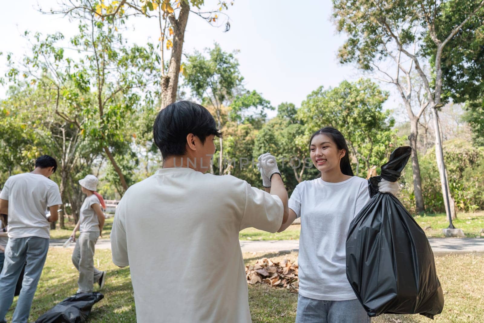 Volunteers celebrate their achievements during a cleanup event, showcasing teamwork and commitment to a cleaner environment.