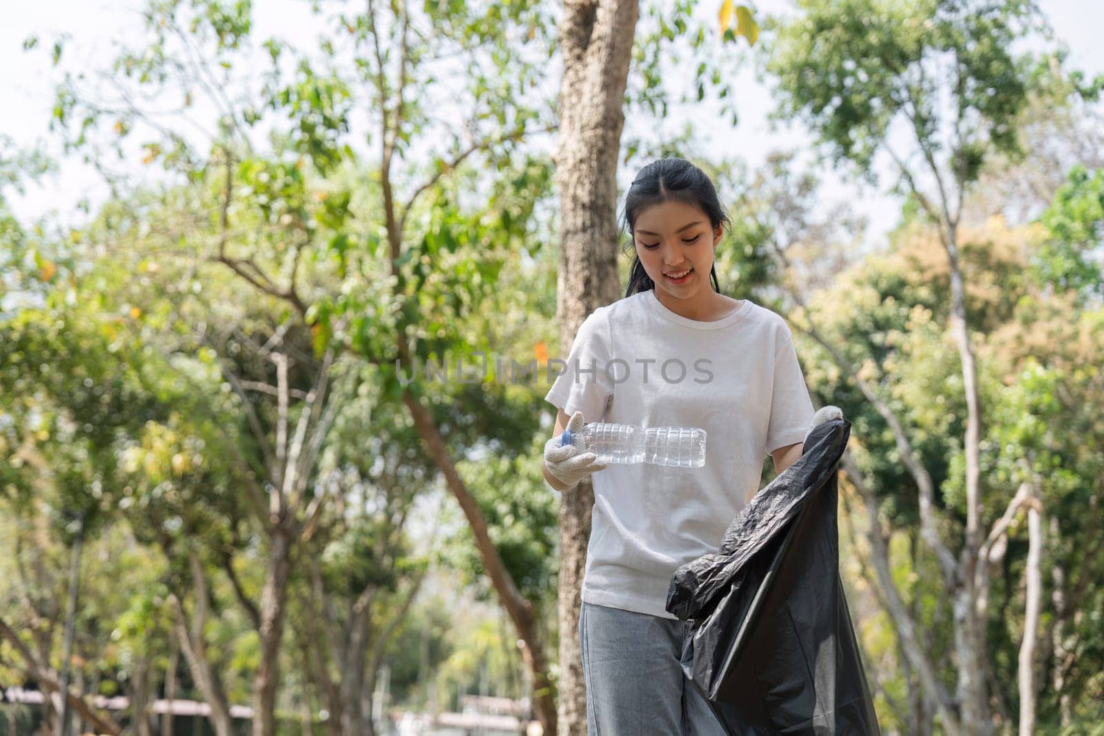 A volunteer happily collects plastic waste, demonstrating commitment to sustainability and environmental health during a cleanup.