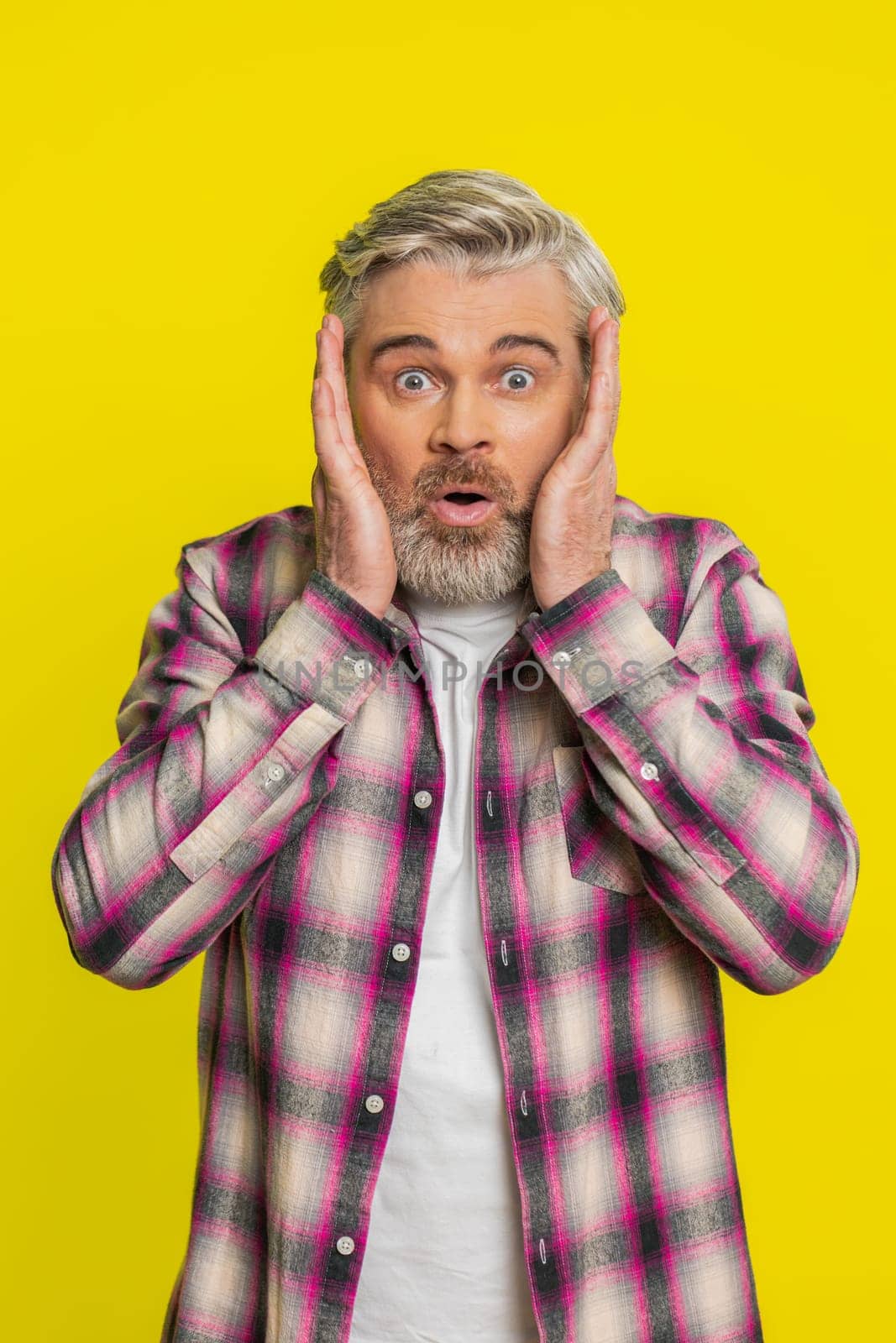 Oh my God, Wow. Excited amazed winner Caucasian man raising hands in surprise looking at camera with big eyes shocked victory goal celebrating success achievement good news. Guy on yellow background