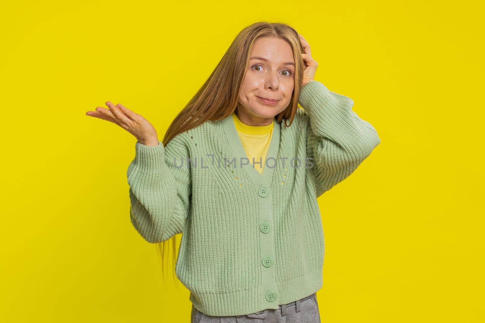 I don't know what to say. Confused Caucasian young woman feeling embarrassed about ambiguous question, having doubts no answer idea, being clueless uncertain. Blonde girl isolated on yellow background