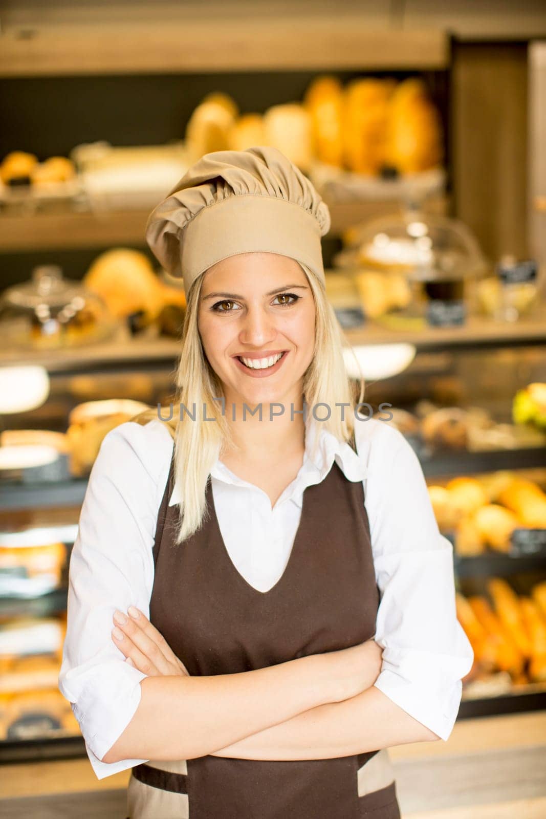 Beautiful young woman smiling confidently posing in her baker shop
