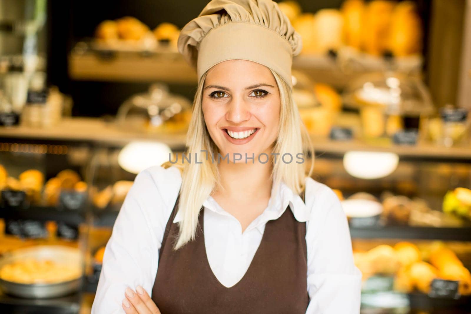 Beautiful young woman smiling confidently posing in her baker shop